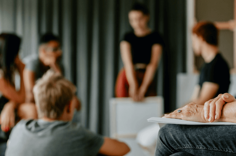 Image of a class of students listening to a presenter in front of a projector screen.