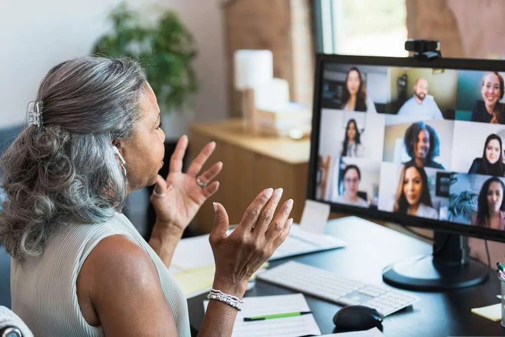 Woman sitting in front of a group Zoom call